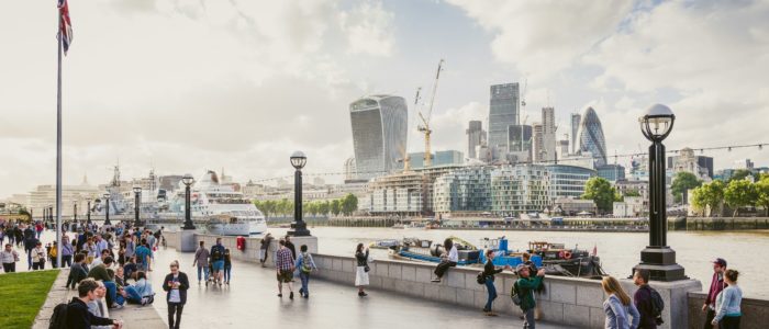 Touristen schauen über die Themse auf die Skyline von London